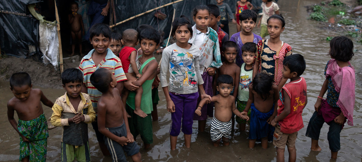 أطفال لاجئون من أبناء الروهينجا يقفون وسط مياه الفياضانات التي تحيط بملاجئ عائلاتهم في كوكس بازار ببنغلاديش ـ صورة من موقع الأمم المتحدة.